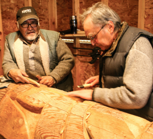 Carvers working on poles that will tell the story of the nations past, present and future