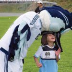 child playing with sport mascot