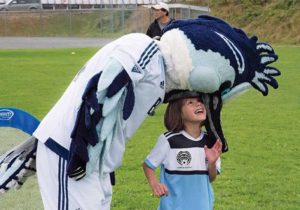 child playing with sport mascot