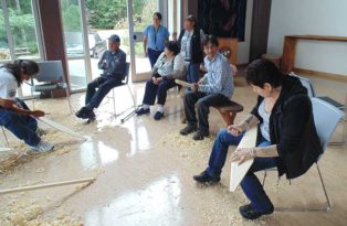 people carving paddles out of wood