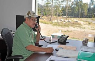 man sitting at office desk and talking on the phone