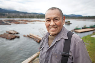 man standing in front of log driving operation