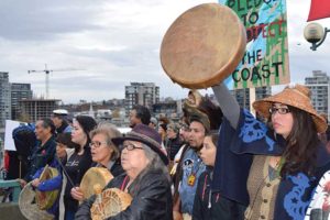 protestors march with drums and signs