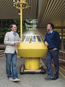 two men standing by wave buoy