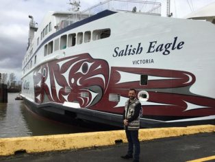 artist in front of his work on a ship