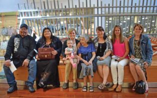 group sitting on art bench