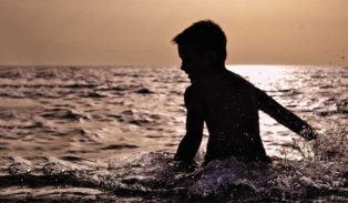 boy playing in the ocean